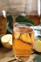 Photo of Glass of delicious apple cider on wooden table