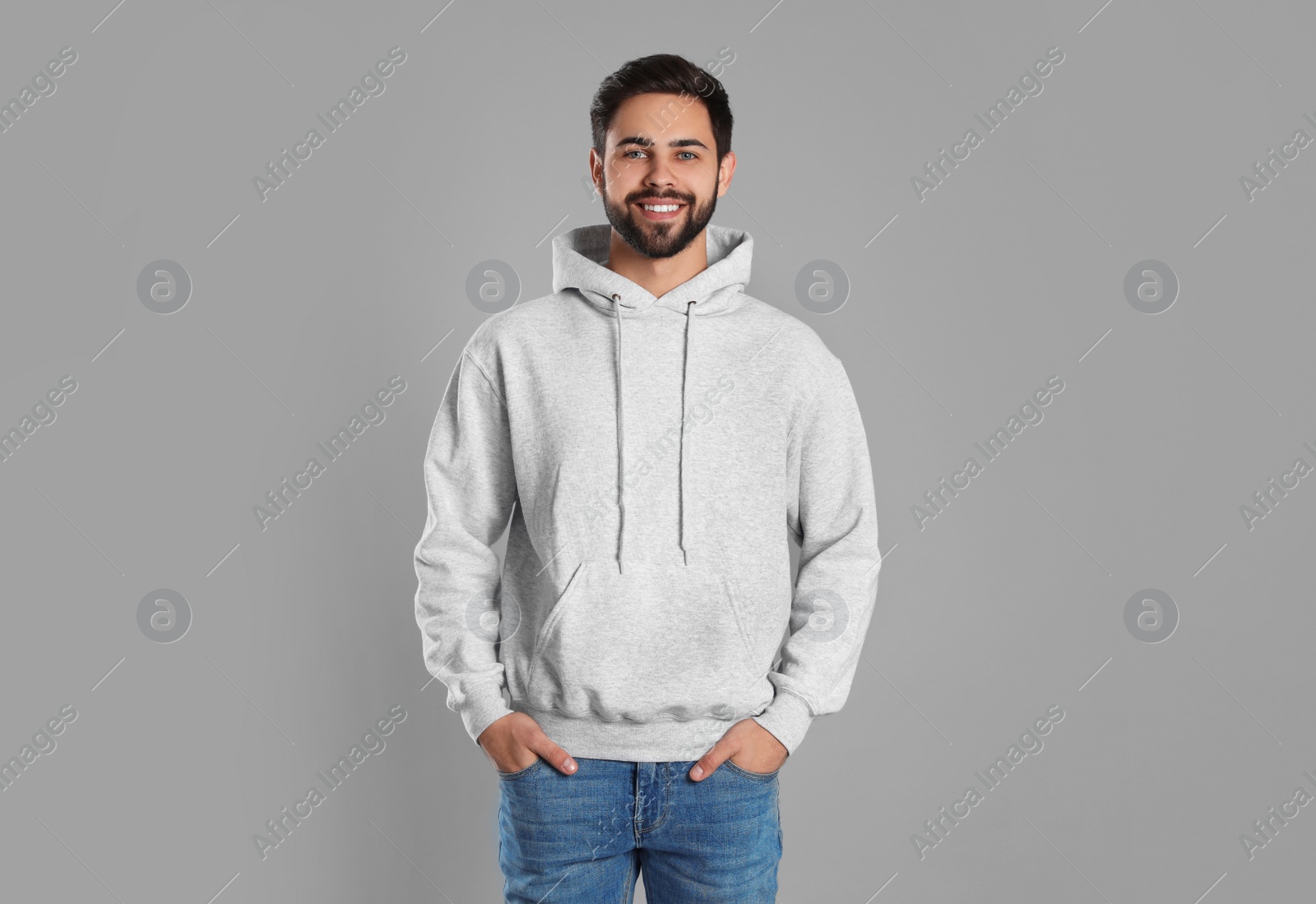 Photo of Portrait of young man in sweater on grey background. Mock up for design