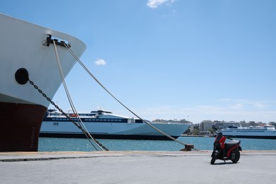 Modern ferry and scooter in sea port on sunny day