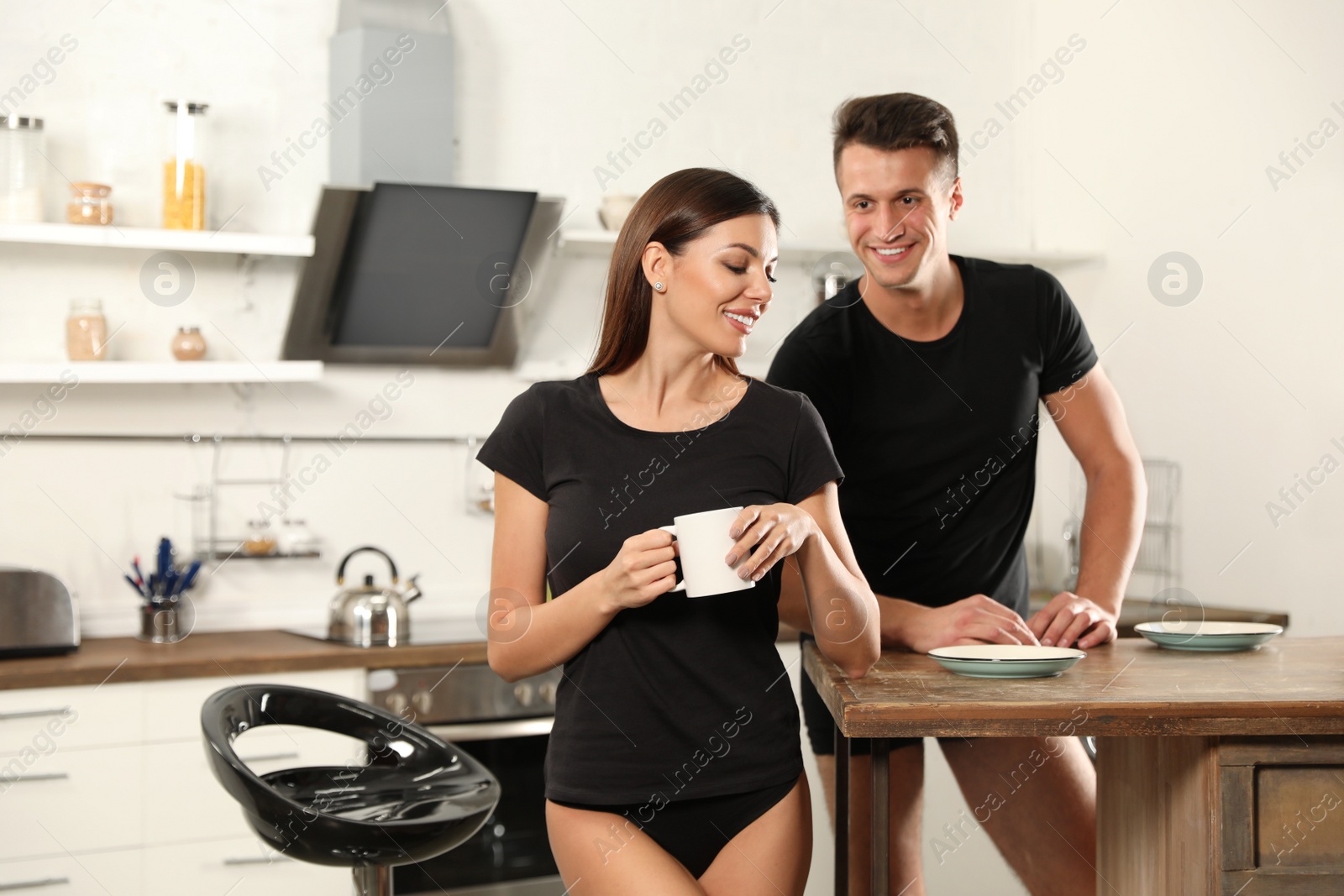 Photo of Happy couple wearing underwear in modern kitchen