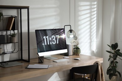 Photo of Modern computer and laptop on wooden desk in room. Interior design
