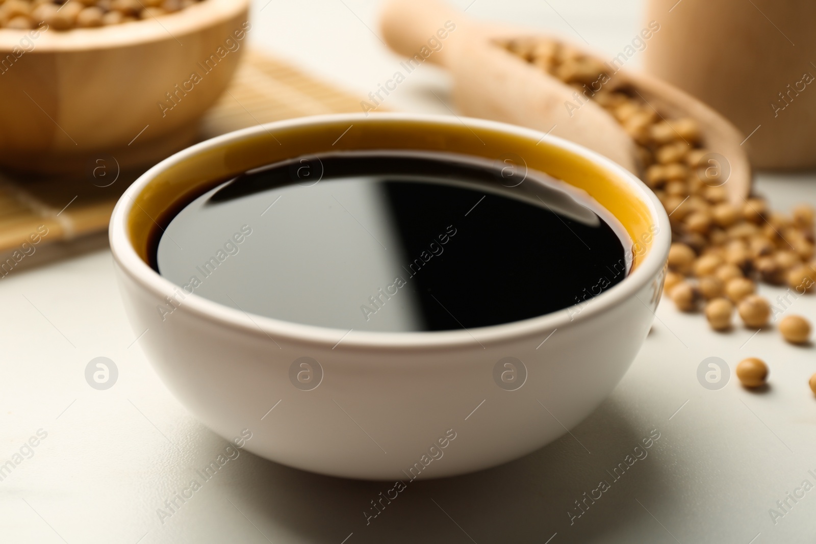Photo of Soy sauce in bowl on white table, closeup