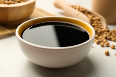 Photo of Soy sauce in bowl on white table, closeup