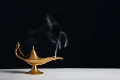 Photo of Aladdin lamp of wishes on table against black background