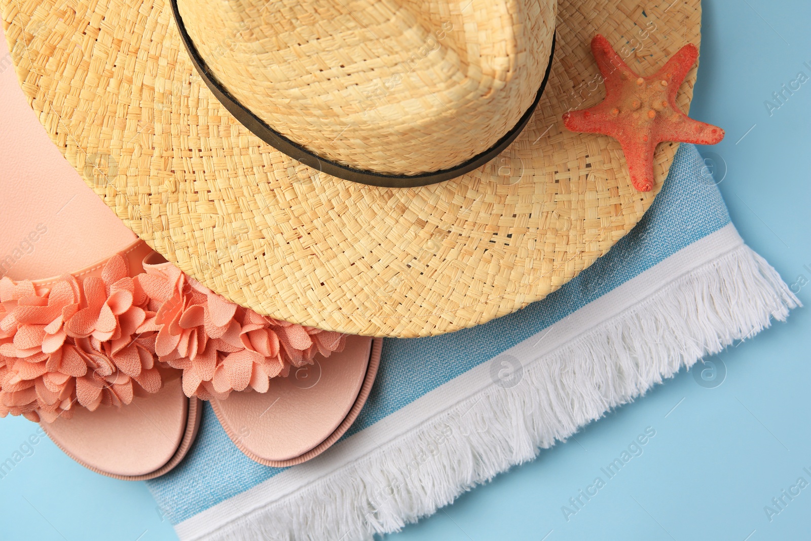 Photo of Flat lay composition with beach accessories on light blue background