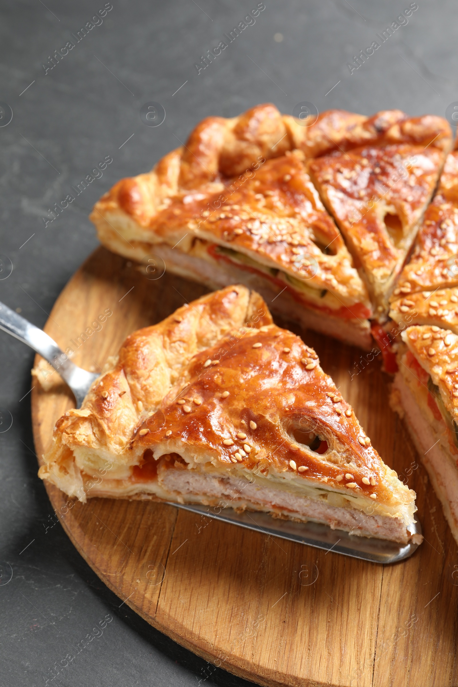 Photo of Cut delicious homemade pie and server on black table, closeup