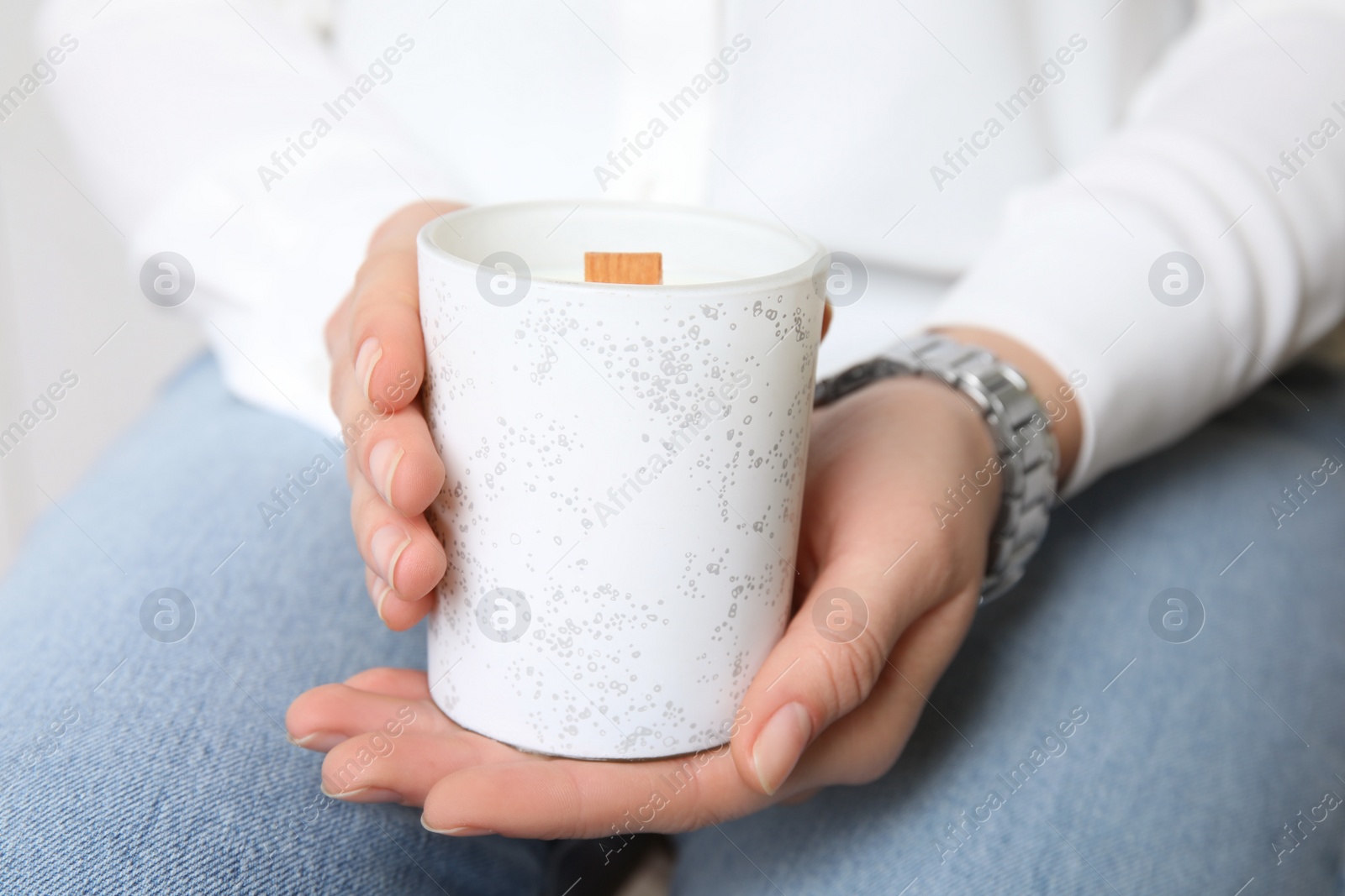 Photo of Woman holding candle with wooden wick, closeup