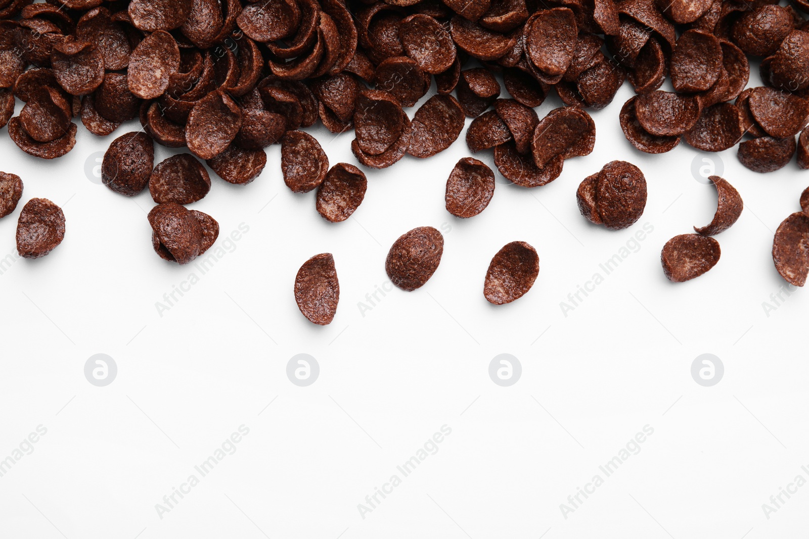 Photo of Breakfast cereal. Chocolate corn flakes on white background, flat lay. Space for text