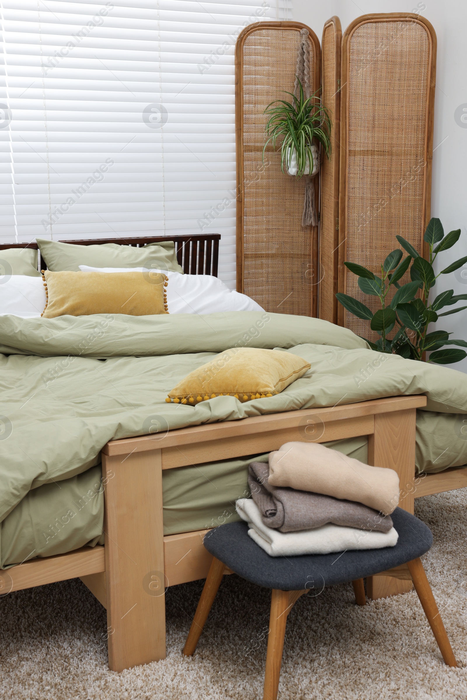 Photo of Comfortable bed and beautiful green houseplants in bedroom