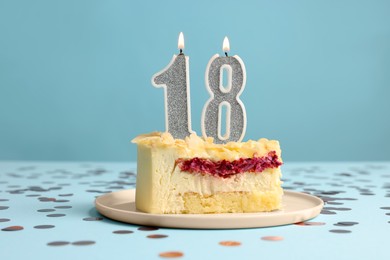 Photo of Coming of age party - 18th birthday. Delicious cake with number shaped candles on light blue background