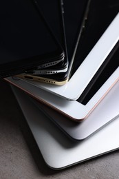 Many different modern gadgets on grey table, closeup