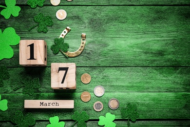 Image of Flat lay composition with block calendar on green wooden table, space for text. Saint Patrick's Day celebration