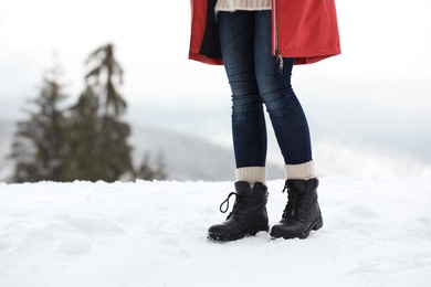 Woman walking outdoors on snowy day, closeup with space for text. Winter vacation