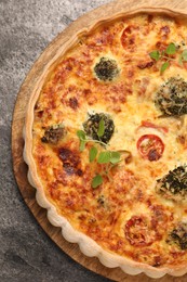 Delicious homemade vegetable quiche on gray table, top view