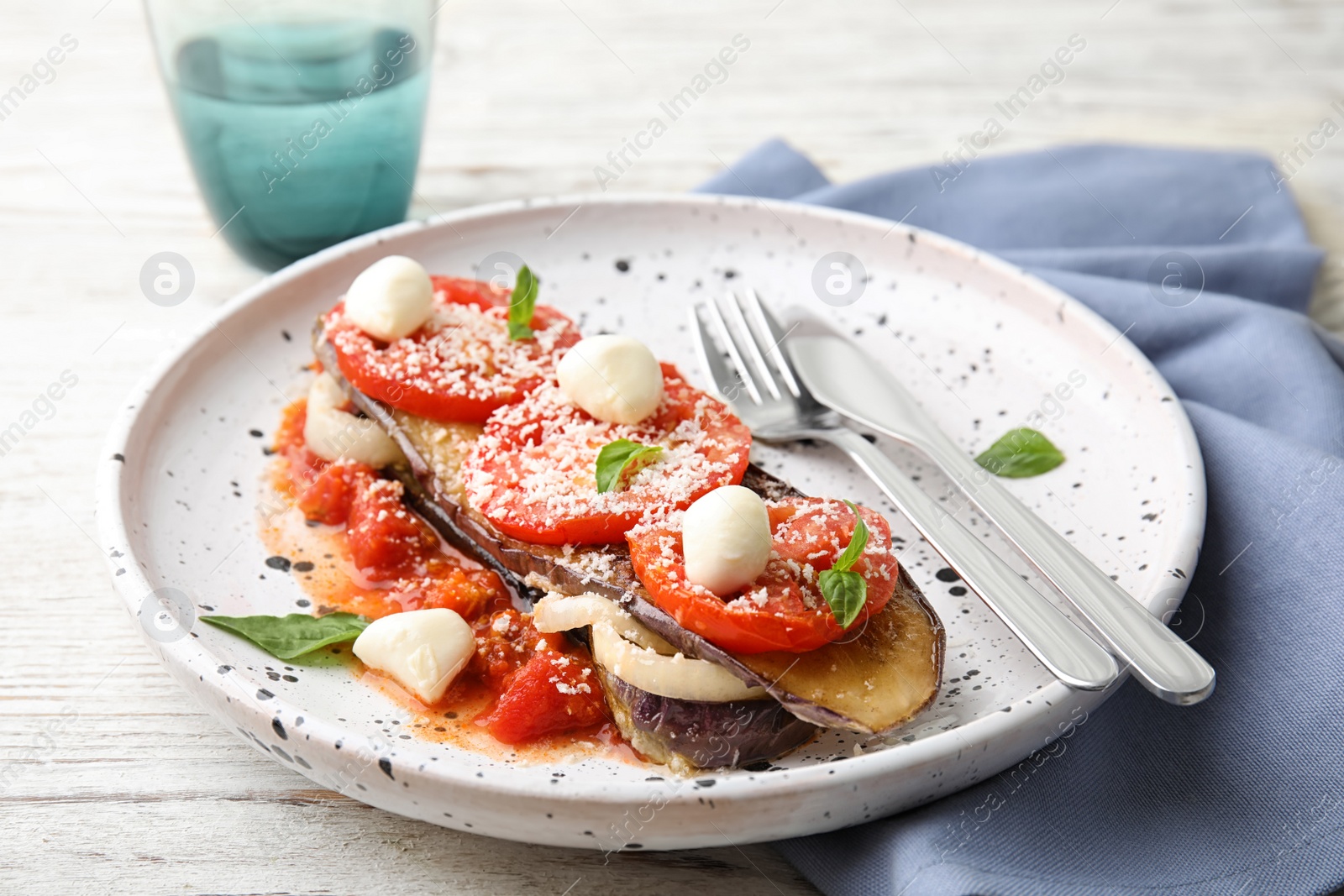 Photo of Baked eggplant with tomatoes, cheese and basil served on wooden table