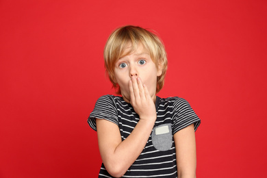 Photo of Portrait of emotional little boy on red background