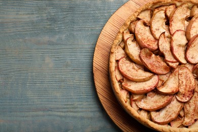 Photo of Delicious apple pie on light blue wooden table, top view. Space for text