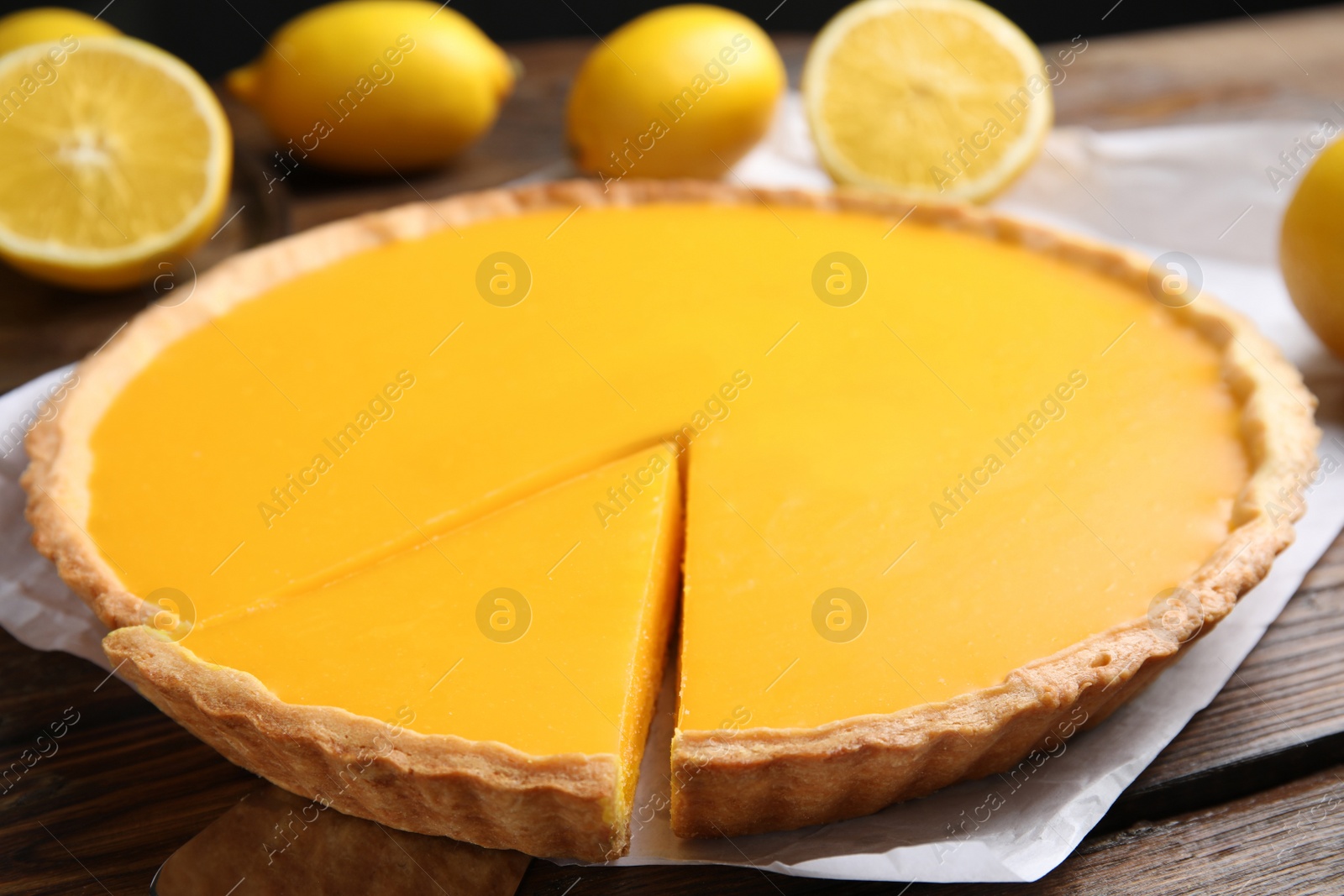 Photo of Delicious homemade lemon pie on wooden table, closeup