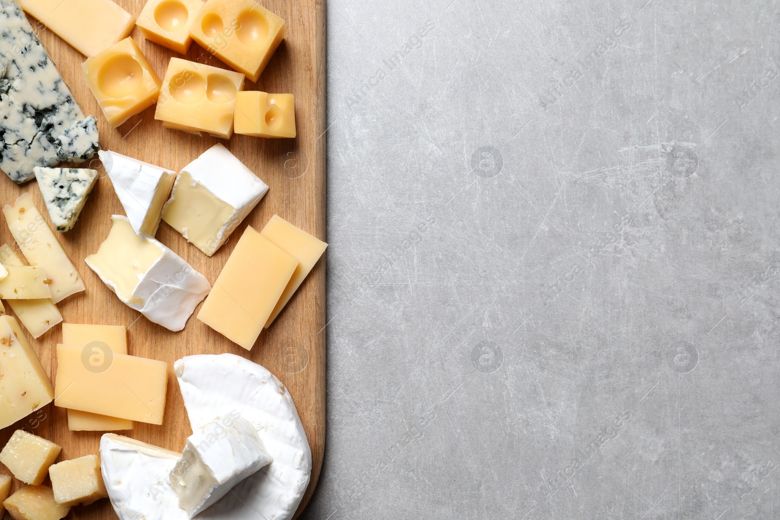 Photo of Cheese plate on light grey table, top view. Space for text