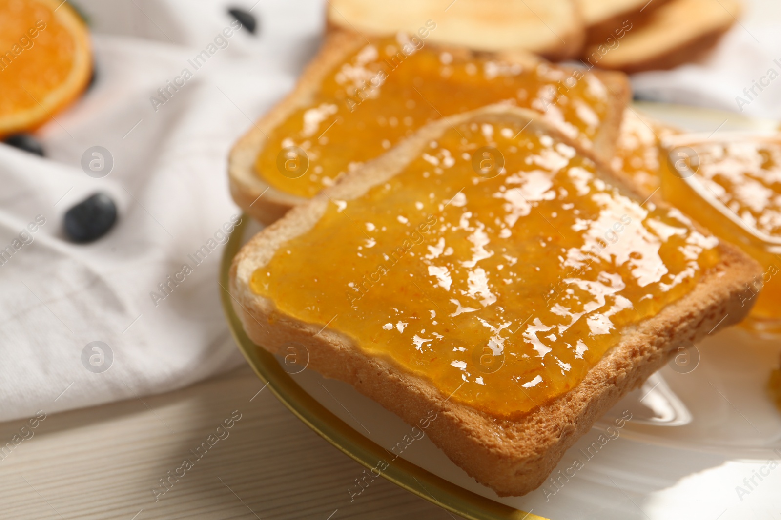 Photo of Delicious toasts with jam served on white wooden table, closeup