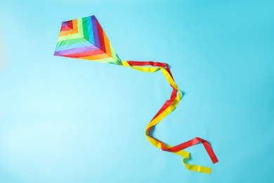 Photo of Bright rainbow kite on light blue background, top view