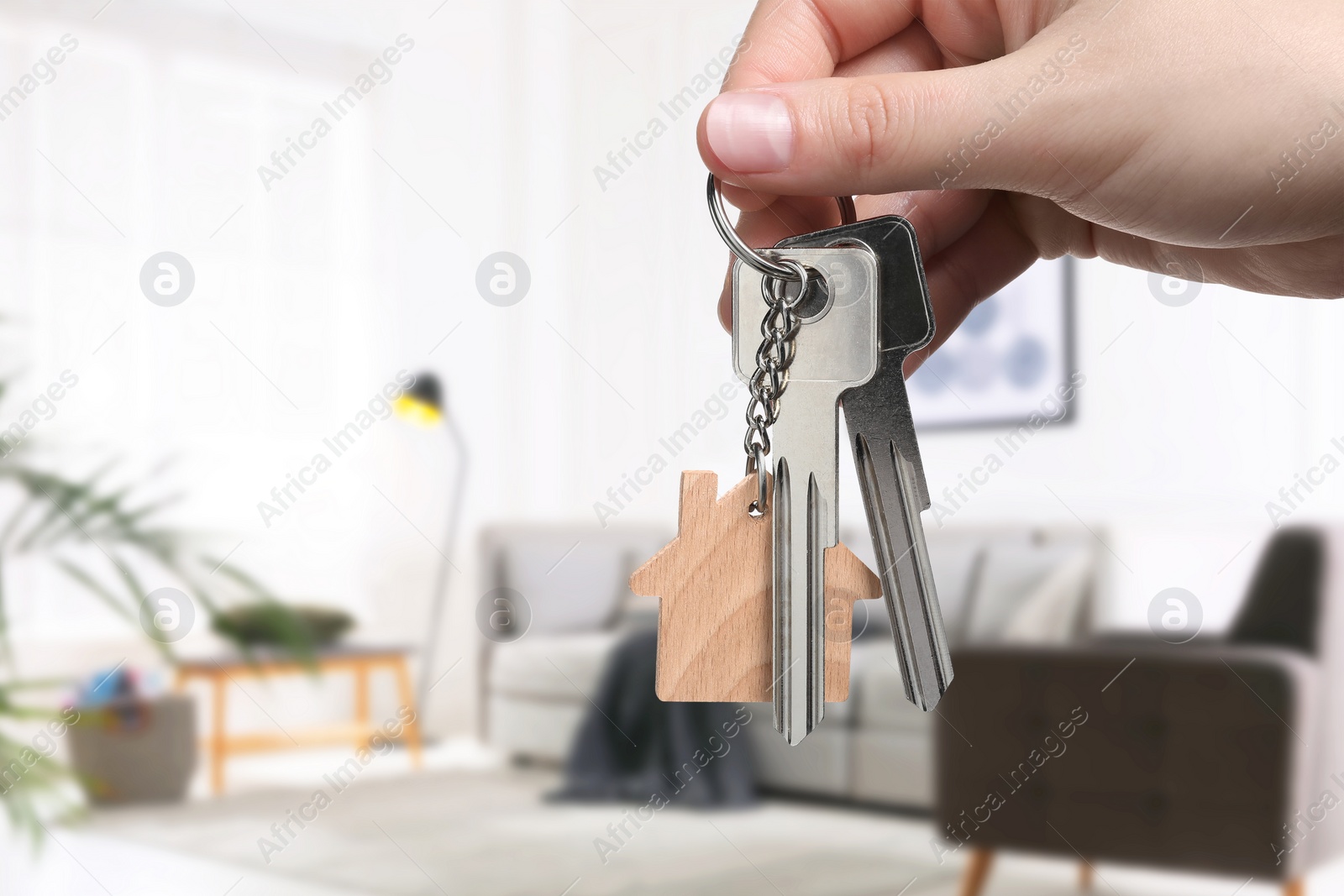 Image of Woman holding house keys in room, closeup