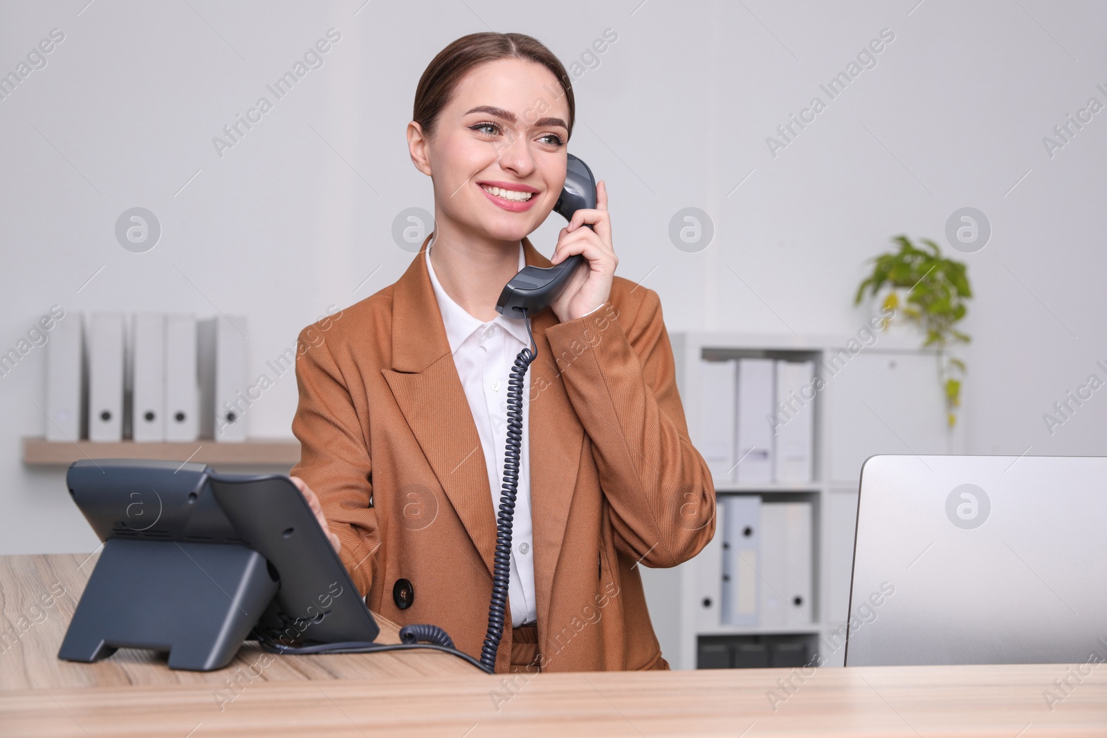 Photo of Female receptionist talking on phone at workplace