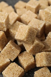 Photo of Brown sugar cubes on table, closeup view