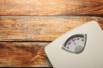 Photo of Weigh scales on wooden table, top view with space for text. Overweight concept