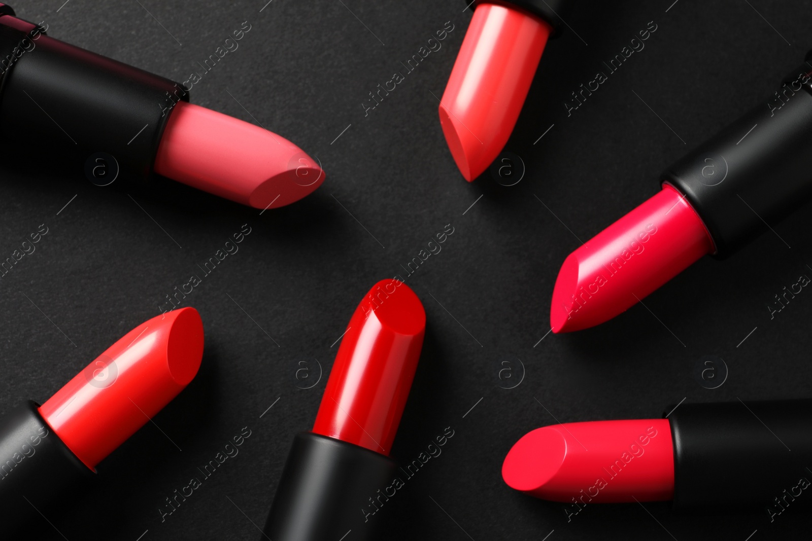 Photo of Beautiful lipsticks on black background, flat lay