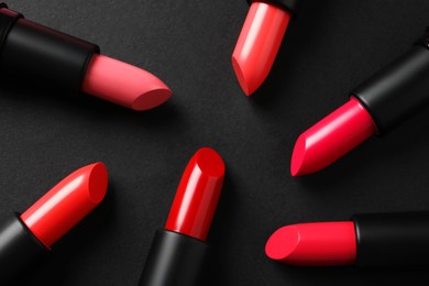 Photo of Beautiful lipsticks on black background, flat lay