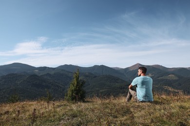 Photo of Man enjoying picturesque view of mountain landscape on sunny day
