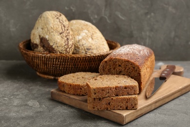 Photo of Tasty freshly baked bread on grey table