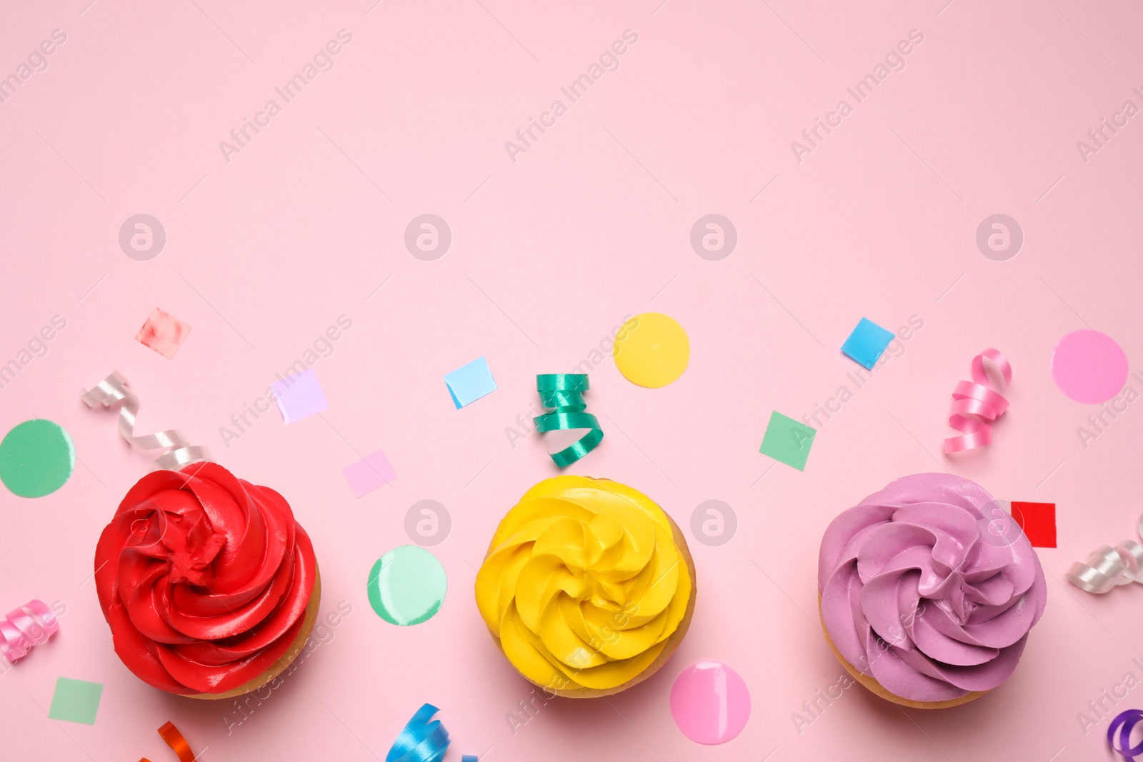 Photo of Colorful birthday cupcakes on light pink background, flat lay. Space for text