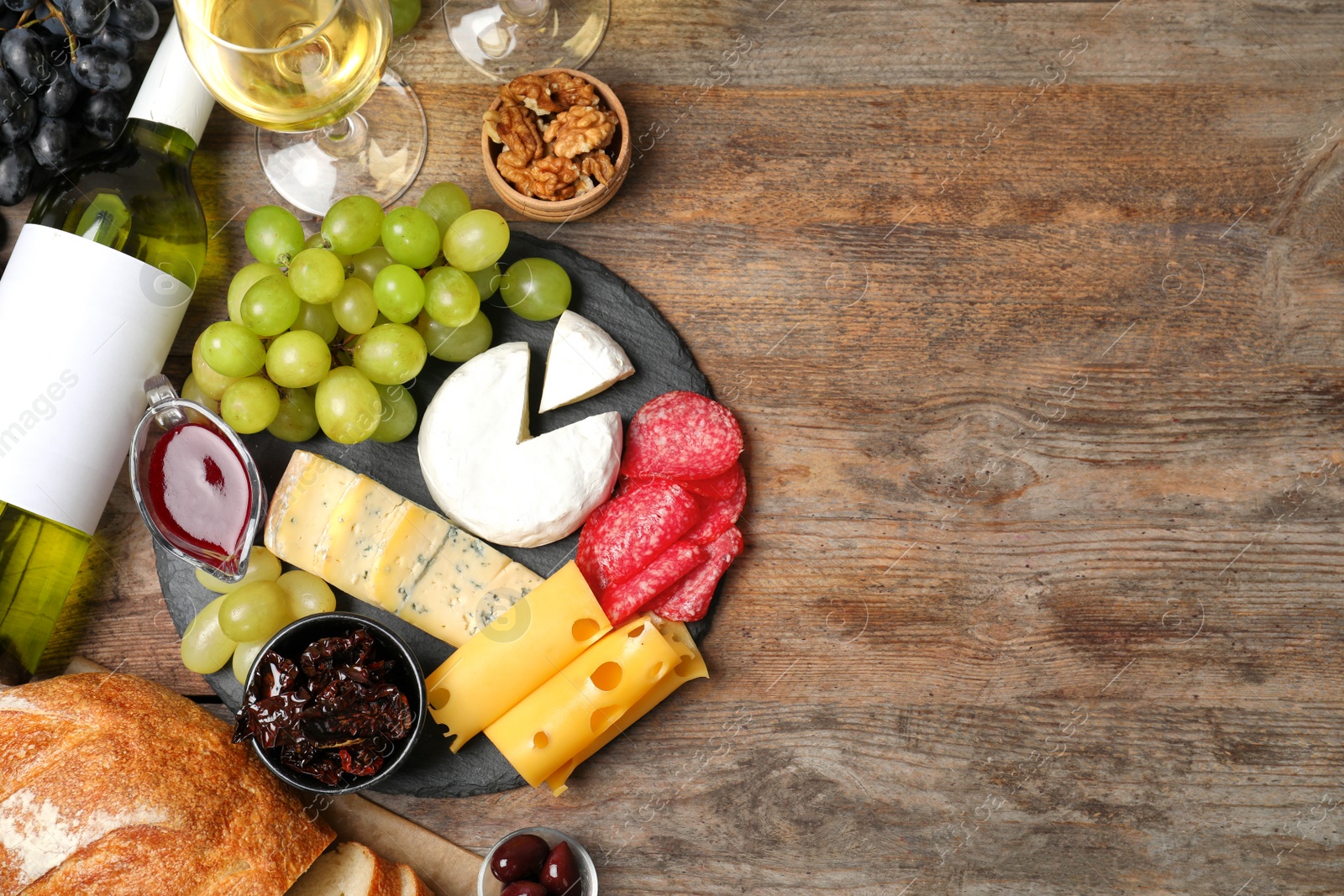 Photo of Flat lay composition with wine, snacks and space for text on wooden background