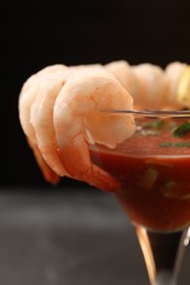 Tasty shrimp cocktail with sauce in glass on blurred background, closeup