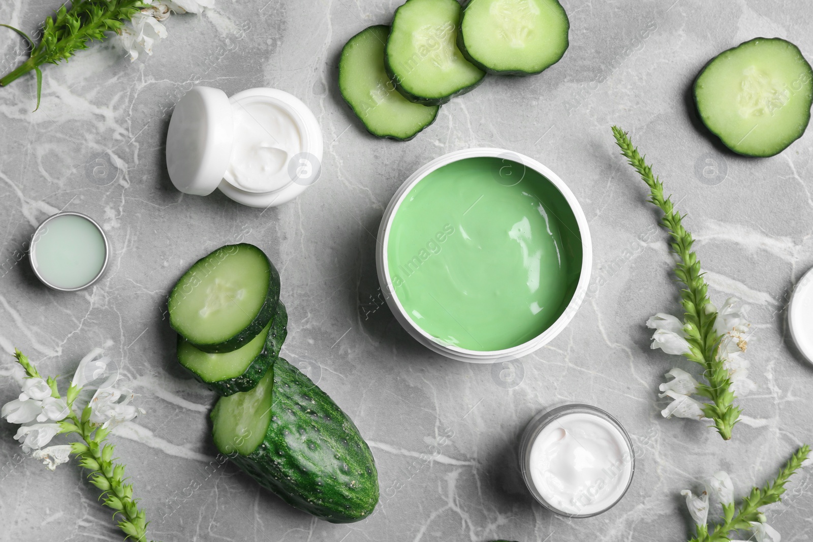 Photo of Flat lay composition with jars of body cream on grey marble background