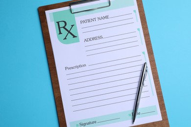 Photo of Clipboard with medical prescription form and pen on light blue background, top view
