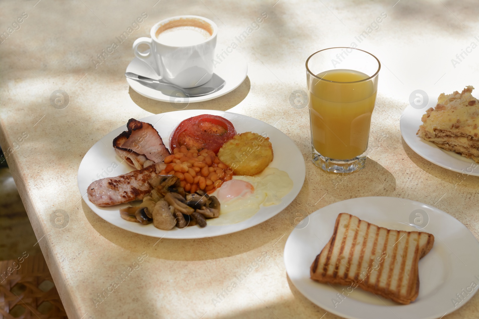 Photo of Delicious breakfast with fried meat and vegetables served on beige table