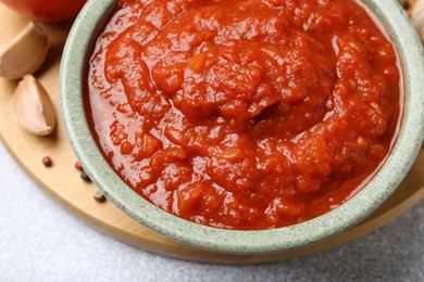 Homemade tomato sauce in bowl on light grey table, closeup