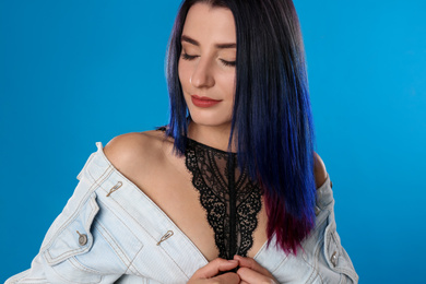 Photo of Young woman with bright dyed hair on blue background