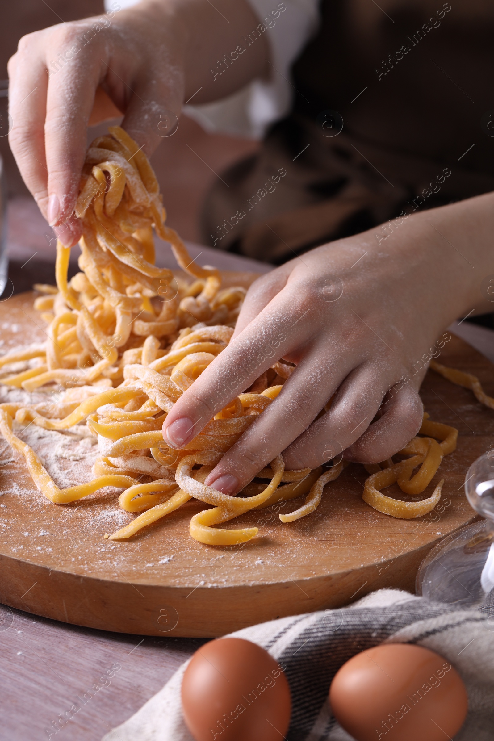 Photo of Woman making homemade pasta at table, closeup