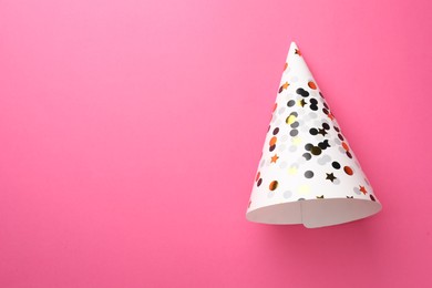 Photo of One beautiful party hat on pink background, top view. Space for text