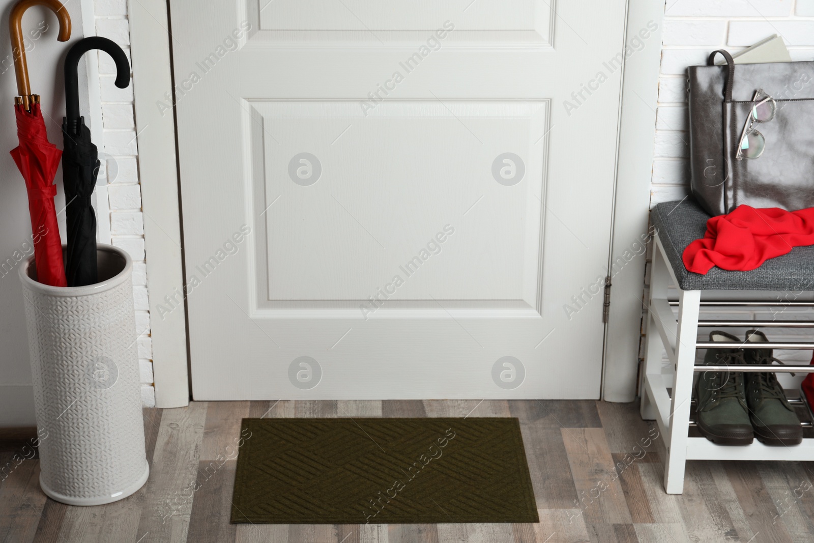 Photo of Clean door mat on wooden floor in hall