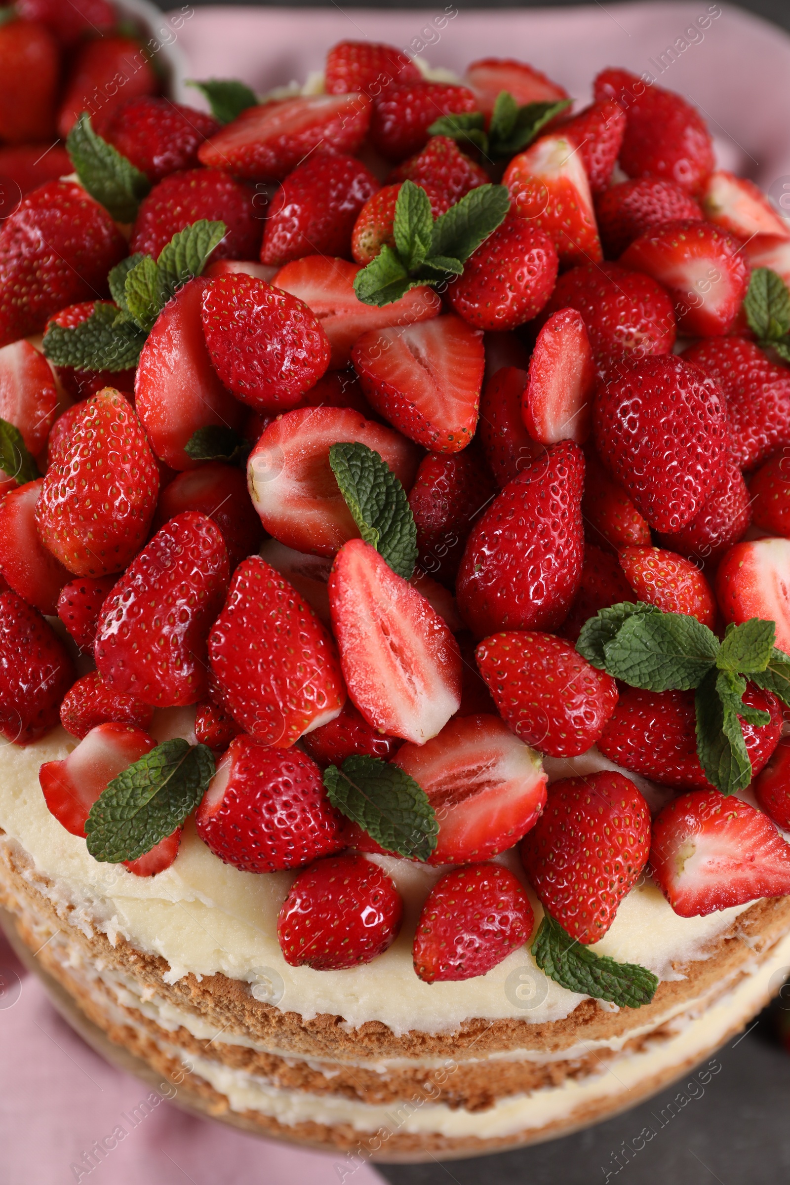 Photo of Tasty cake with fresh strawberries and mint on table, above view