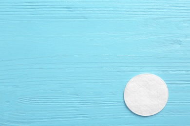 Photo of Cotton pad on wooden background, top view. Space for text