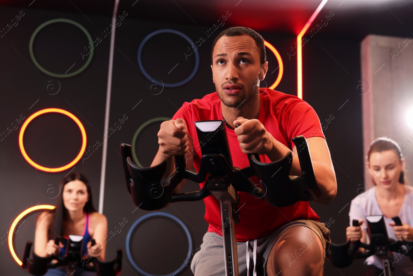 Photo of Group of people training on exercise bikes in fitness club