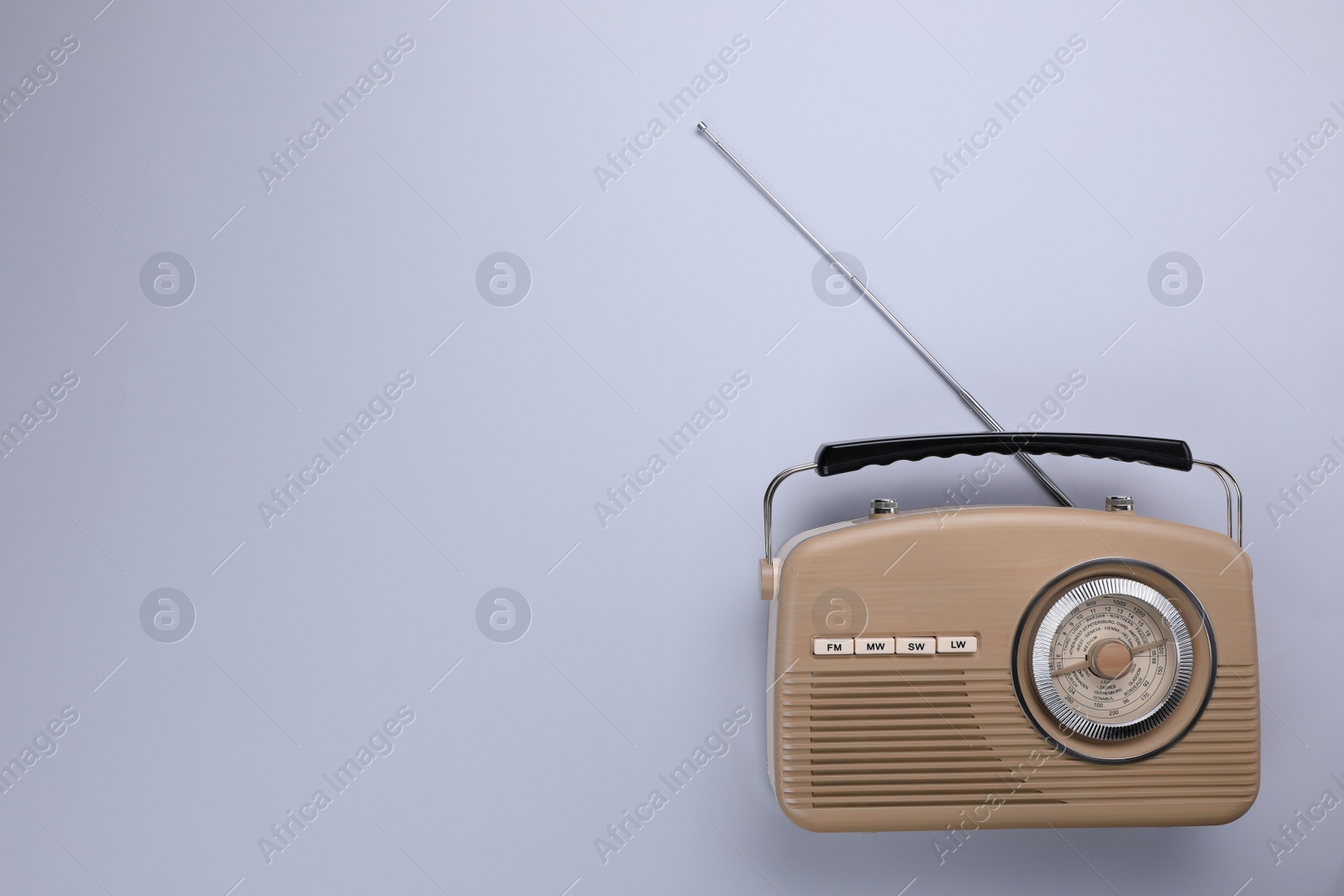 Photo of Retro radio receiver on light grey background, top view. Space for text