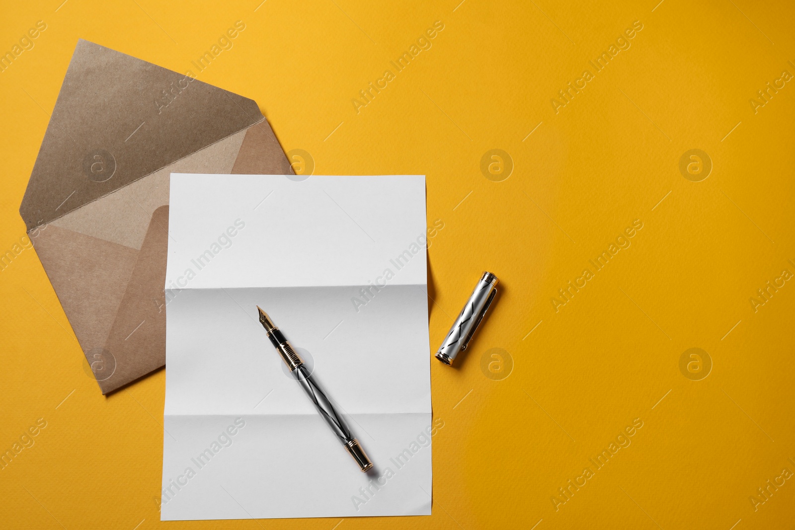 Photo of Blank sheet of paper, letter envelope and pen on orange background, top view. Space for text