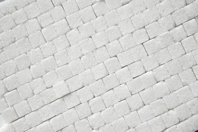 Photo of Refined sugar cubes as background, top view